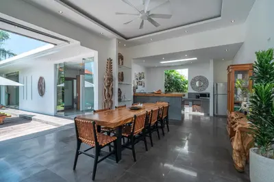 a kitchen and dining room with a wooden table and chairs at Incredible 3BR Villa In The Heart Of Seminyak in Seminyak