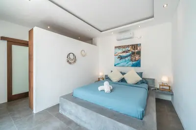 a bedroom with a blue bed in a room at Incredible 3BR Villa In The Heart Of Seminyak in Seminyak