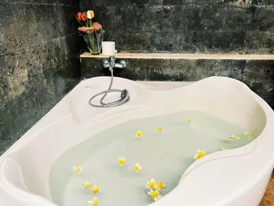 a bath tub with flowers in the water at Cempaka Villa in Pesanggaran