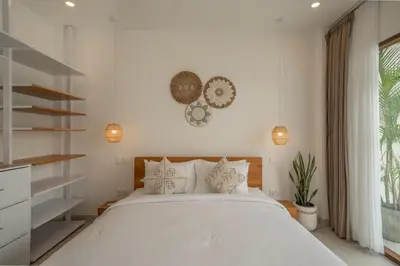 a bedroom with a large white bed and shelves at Cute 2 Bedrooms Villa in Canggu in Canggu