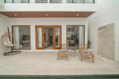 a patio with chairs and a table in a house at Cute 2 Bedrooms Villa in Canggu in Canggu
