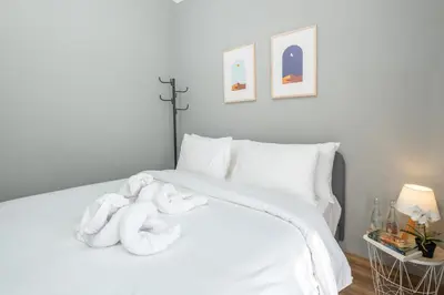 a white bed with a pile of towels on it at Rivera Seminyak 1 in Seminyak