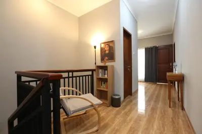a room with a staircase with a chair and a book shelf at Rivera Seminyak 1 in Seminyak