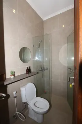 a bathroom with a toilet and a glass shower at Rivera Seminyak 1 in Seminyak