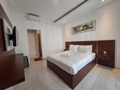 a bedroom with a large bed in a room at Saphala Suites Seminyak in Seminyak
