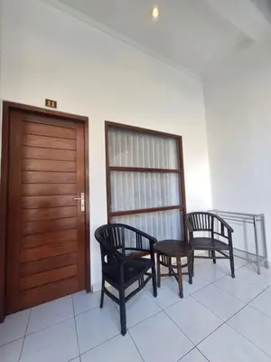 two chairs and a wooden door in a room at Saphala Suites Seminyak in Seminyak