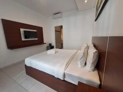 a bedroom with a bed and a tv on the wall at Saphala Suites Seminyak in Seminyak