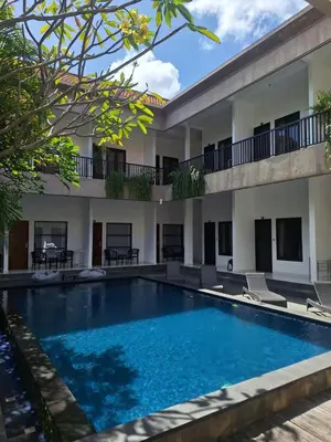 a swimming pool in front of a building at Saphala Suites Seminyak in Seminyak