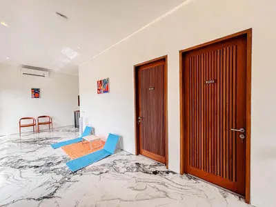 an empty room with two chairs and two doors at Budayana Villa in Jimbaran