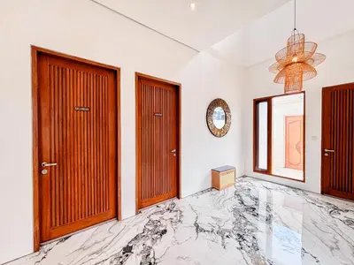 a room with two doors and a marble floor at Budayana Villa in Jimbaran