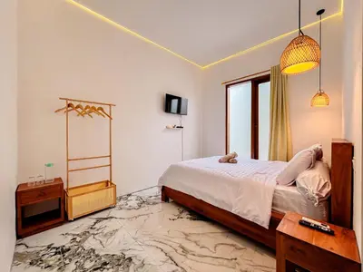 a bedroom with a bed with a teddy bear on it at Budayana Villa in Jimbaran