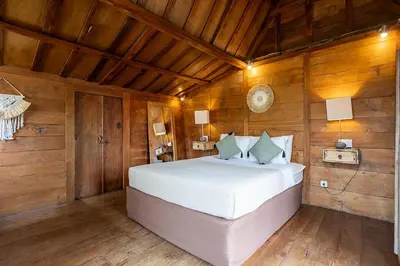 a bedroom with a bed in a room with wooden walls at Central Oberoi Seminyak Newly Renovated Villa Riva in Seminyak