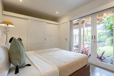 a bedroom with a bed and a large window at Central Oberoi Seminyak Newly Renovated Villa Riva in Seminyak