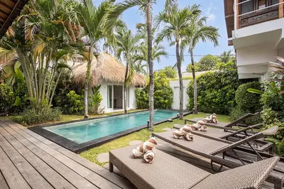 a villa with a swimming pool and lounge chairs at Central Oberoi Seminyak Newly Renovated Villa Riva in Seminyak