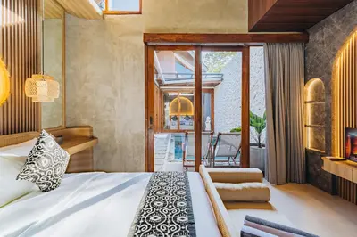 a bedroom with a bed and a living room at iRini Villas in Nusa Dua