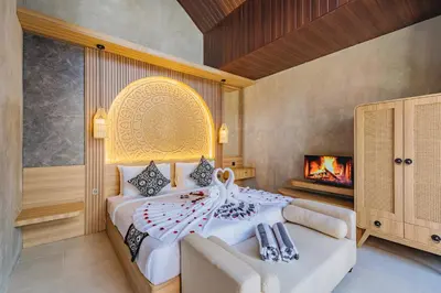 a bedroom with a large bed and a fireplace at iRini Villas in Nusa Dua