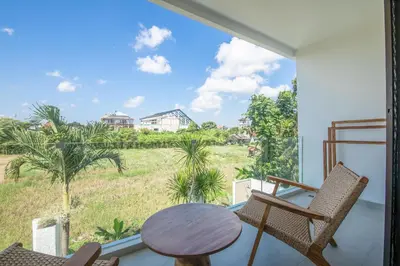 a balcony with a table and chairs and a large window at 4 Bd Seminyak Scenic Rice Views 4 mins to Beach in Seminyak