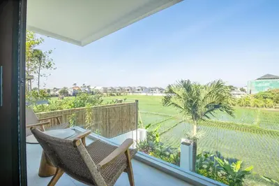 a balcony with chairs and a view of a field at 4 Bd Seminyak Scenic Rice Views 4 mins to Beach in Seminyak
