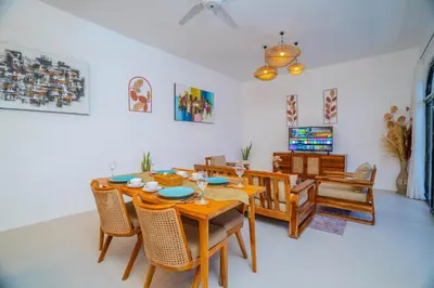 a dining room with a wooden table and chairs at Villa Radha Seminyak in Seminyak