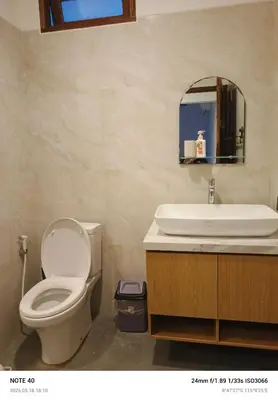 a bathroom with a toilet and a sink and a mirror at Lucky Villa Jimbaran Penta in Jimbaran