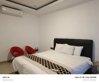 a bedroom with a bed and two red chairs at Lucky Villa Jimbaran Penta in Jimbaran