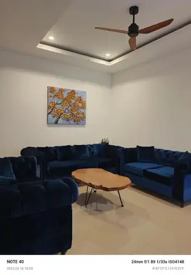 a living room with a blue couch and a table at Lucky Villa Jimbaran Penta in Jimbaran