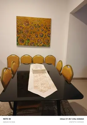 a dining room table with chairs and a painting on the wall at Lucky Villa Jimbaran Penta in Jimbaran