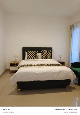 a bedroom with a large bed with a black headboard at Lucky Villa Jimbaran Penta in Jimbaran