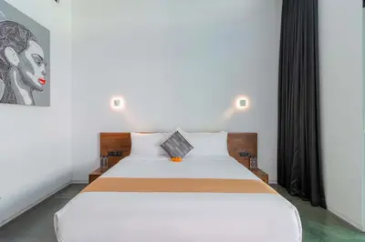 a bedroom with a large white bed with black curtains at Stylish 3BR Villa with Swim-Up Bar in Seminyak in Seminyak