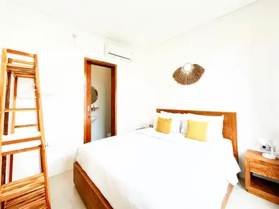 a white bedroom with a bed and a ladder at Villa De Tutti - 2BR Pool Villa Near Seminyak in Seminyak