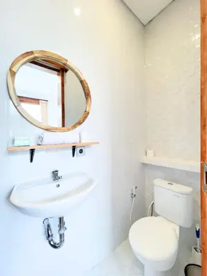 a bathroom with a white toilet and a mirror at Villa De Tutti - 2BR Pool Villa Near Seminyak in Seminyak