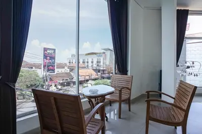 a dining room with a table and chairs and a large window at Prima Inn in Kuta