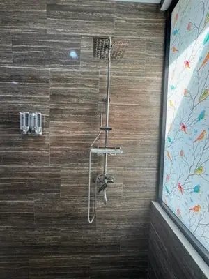a shower in a bathroom with a wooden wall at Mahome - Near Finn's and Atlas Beach Club in Canggu