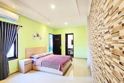 a bedroom with a bed and a brick wall at 4 Bedroom Home with Pool near Canggu and Seminyak in Kerobokan