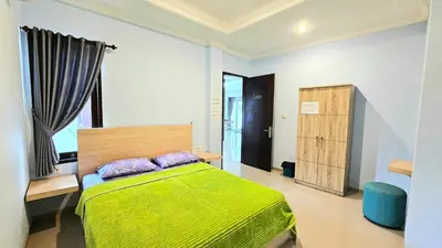 a bedroom with a bed with a green blanket at 4 Bedroom Home with Pool near Canggu and Seminyak in Kerobokan