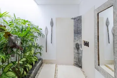 a bathroom with a shower and plants at Villa Naema by Pertama Management in Seminyak