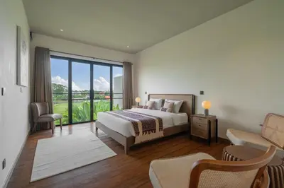 a bedroom with a bed and a large window at Villa Merengue by BaliSuperHost in Seminyak