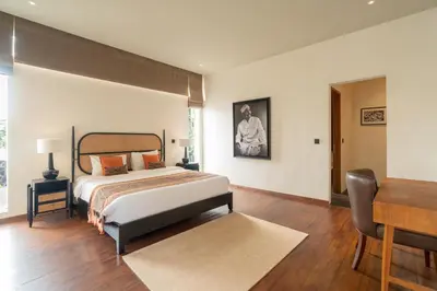 a bedroom with a bed and a table and a desk at Villa Merengue by BaliSuperHost in Seminyak