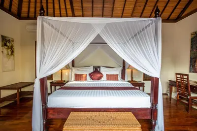 a bedroom with a bed with a canopy at Villa Saffron Seminyak Bali in Seminyak