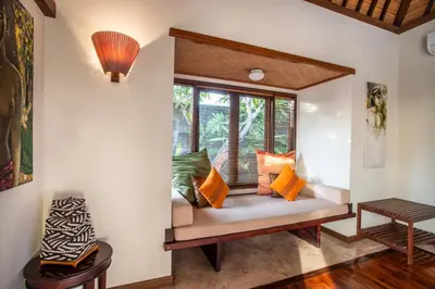 a room with a bench with pillows and a window at Villa Saffron Seminyak Bali in Seminyak