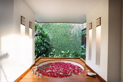 a bathroom with a large tub filled with pink flowers at Villa Saffron Seminyak Bali in Seminyak