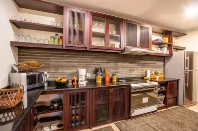 a kitchen with a counter with a microwave and a refrigerator at Villa Saffron Seminyak Bali in Seminyak