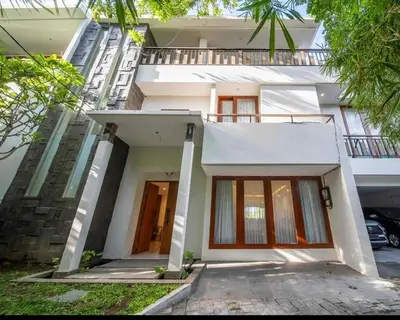 a white house with a front door and trees at Avela bali villa in Kerobokan