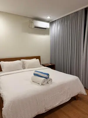 a bedroom with a white bed with towels on it at Avela bali villa in Kerobokan