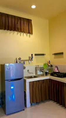 a kitchen with a refrigerator and a sink at Rach APT in Kerobokan