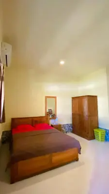 a bedroom with a bed and a dresser at Rach APT in Kerobokan