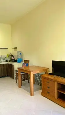 a kitchen with a wooden table and a desk at Rach APT in Kerobokan