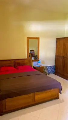 a bedroom with a wooden bed and a mirror at Rach APT in Kerobokan