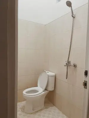 a bathroom with a toilet and a shower at Sukanadi's Homestay in Legian