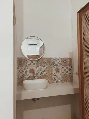 a bathroom with a sink and a mirror at Sukanadi's Homestay in Legian